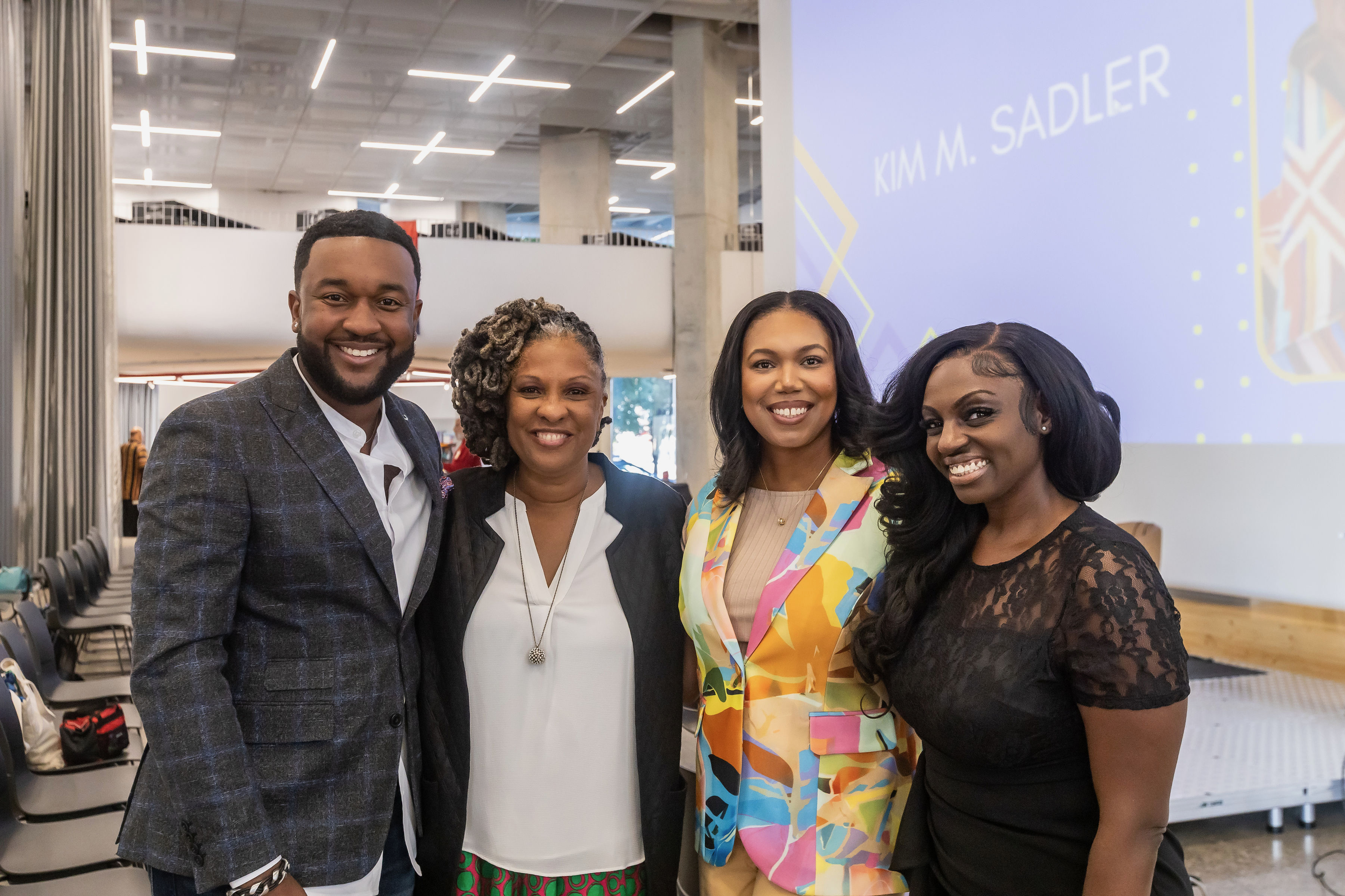 Nikki B at a community speaking event with panelists